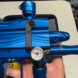 blue custom-milled Worr game product(WGP) Autococker-style paintball marker features an aftermarket vertical feedneck, an Empire pneumatic ram, and a WGP-style frame.