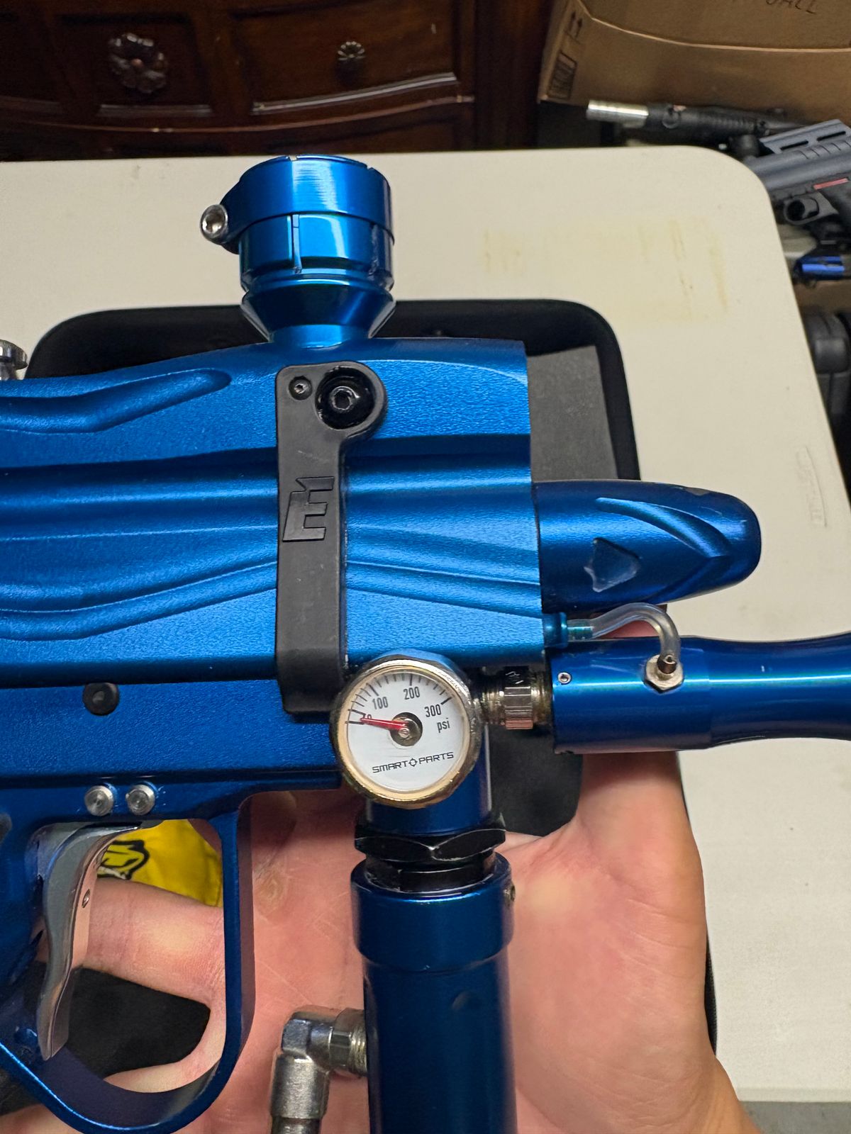 blue custom-milled Worr game product(WGP) Autococker-style paintball marker features an aftermarket vertical feedneck, an Empire pneumatic ram, and a WGP-style frame.